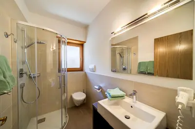 a bathroom with a sink and a shower and a toilet at Residence Krone in Schenna