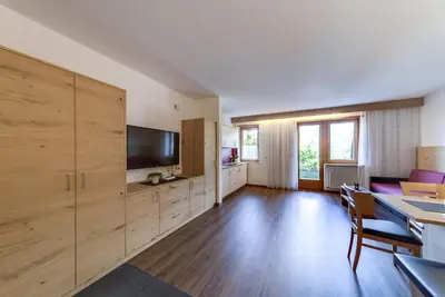 a living room with a flat screen tv and a couch at Residence Krone in Schenna