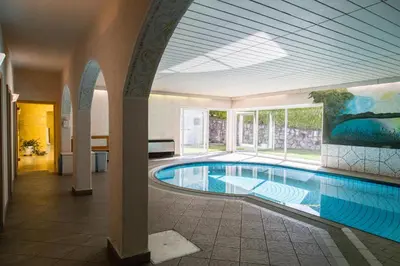 a large swimming pool in a building with a ceiling at Residence Krone in Schenna