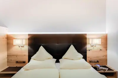 a bedroom with a bed with two pillows at Residence Krone in Schenna