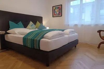 a bedroom with a large bed with a black headboard at Apartment Alpenflair City Meran in Merano