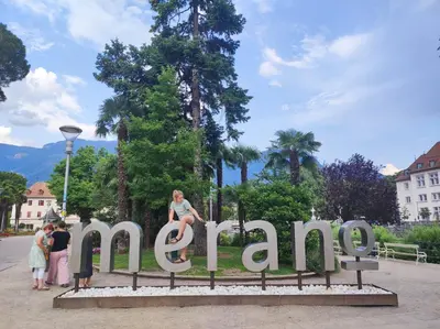 a woman sitting on a sign that says amazon at Apartment Alpenflair City Meran in Merano