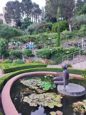 a statue of a little girl in a pond in a garden at Apartment Alpenflair City Meran in Merano