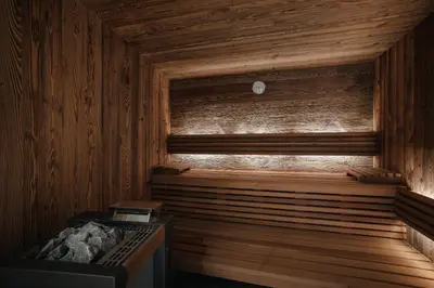 a sauna with a wooden paneled wall and a wooden at Pescosta Chalet Luxury Living in San Vigilio Di Marebbe