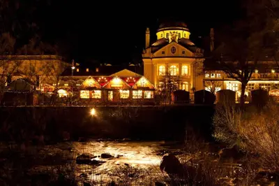 a large building with lights on it at night at Apartment Anna in Merano