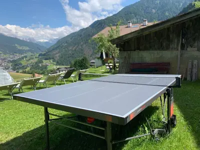 a ping pong table in front of a house at Apartments Stroblhof in Ortisei