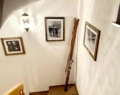 a hallway with a guitar on a wall with pictures at Apartments Stroblhof in Ortisei