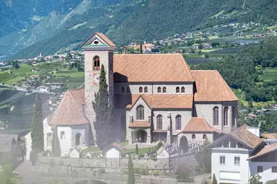 a large building with a clock tower on a hill at Garni Dürrenstein in Schenna