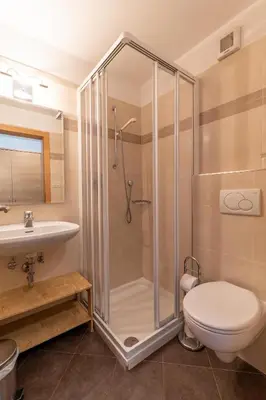 a bathroom with a shower and a toilet and a sink at Garni Dürrenstein in Schenna