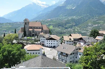 a town with a clock tower in a valley with mountains at Garni Dürrenstein in Schenna