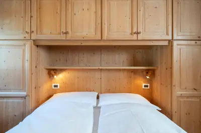 a bedroom with wooden cabinets and a bed in it at Ciasa Buro - Thaus in Moena