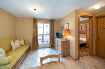 a living room with a couch and a bed at Ciasa Buro - Thaus in Moena
