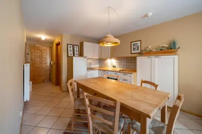 a kitchen with a wooden table and chairs at Ciasa Buro - Thaus in Moena