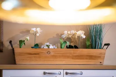 a wooden box with flowers on top of a dresser at Ciasa Buro - Thaus in Moena