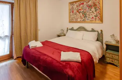 a bedroom with a large bed with a red blanket at Cà Enrosadira primo piano in San Vito di Cadore