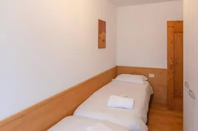 a small room with two beds in it at Cà Enrosadira primo piano in San Vito di Cadore