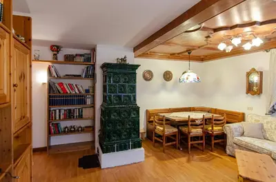 a living room with a table and a book shelf at Cà Enrosadira primo piano in San Vito di Cadore