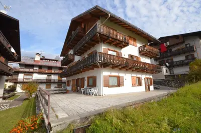 a building with a balcony on the side of it at Cà Enrosadira primo piano in San Vito di Cadore
