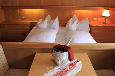 a hotel room with a bed and a table with a mortar and pestle at Albergo Alisander in Corvara in Badia