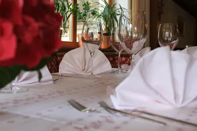 a table with wine glasses and napkins on it at Albergo Alisander in Corvara in Badia
