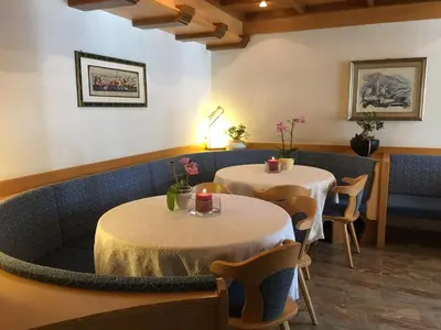 a restaurant with two tables and chairs with candles at Albergo Alisander in Corvara in Badia