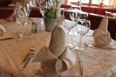 a table with silverware and napkins on a table at Albergo Alisander in Corvara in Badia