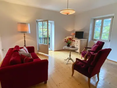 a living room with two red couches and a table at APARTMENT im garten 9 in Gargazzone