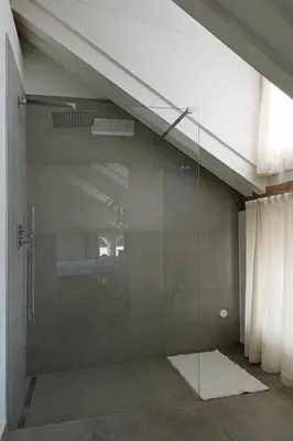 a shower with a glass door in a room at Historic Rooms and Apartments in the City Centre of Bolzano in Bolzano
