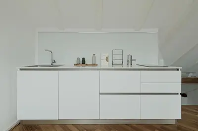 a kitchen with white cabinets and a sink at Historic Rooms and Apartments in the City Centre of Bolzano in Bolzano