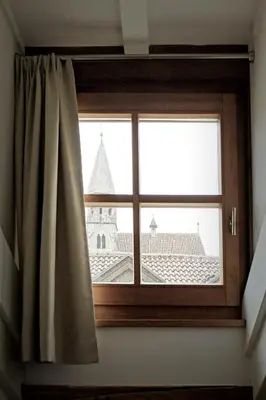 a window with a view of a church at Historic Rooms and Apartments in the City Centre of Bolzano in Bolzano