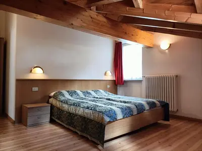 a bedroom with a bed and a wooden cabinet at Appartamenti Villa Maria in Canazei
