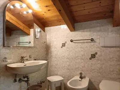a bedroom with a bed and a wooden floor at Appartamenti Villa Maria in Canazei