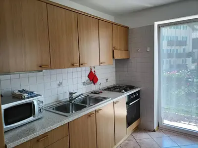 a kitchen with a table and a dining room with a table at Appartamenti Villa Maria in Canazei