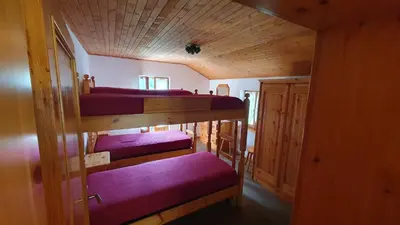 a room with four bunk beds in a cabin at Appartamenti Nonno Gianni in Rocca Pietore