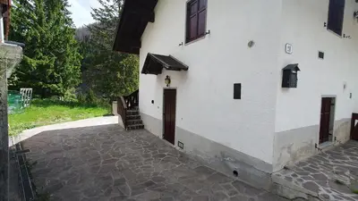 a white building with a door and a staircase at Appartamenti Nonno Gianni in Rocca Pietore