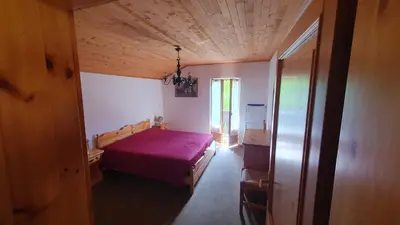 a bedroom with a bed with a purple blanket at Appartamenti Nonno Gianni in Rocca Pietore