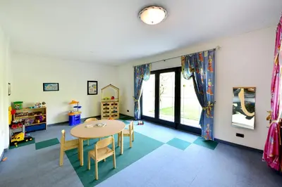 a childs play room with a table and chairs at Hotel Greifenstein in Terlano