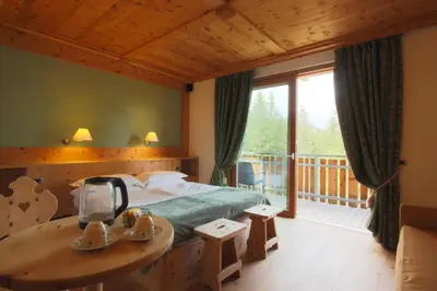 a bedroom with a bed and a balcony at Ciasa Vervei in Cortina dʼAmpezzo