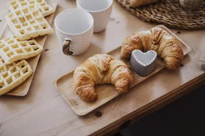 a table with waffles and croissants on a table at Töllhof Studio Stube in Bressanone