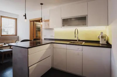 a kitchen with white cabinets and a sink at Töllhof Studio Stube in Bressanone
