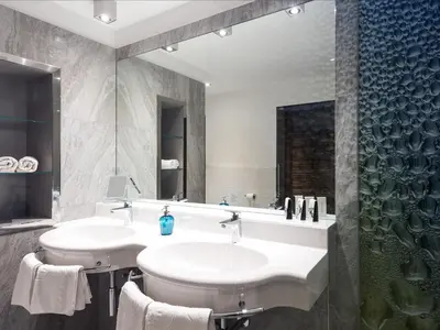 a bathroom with two sinks and a shower at Hotel Ifinger in Schenna