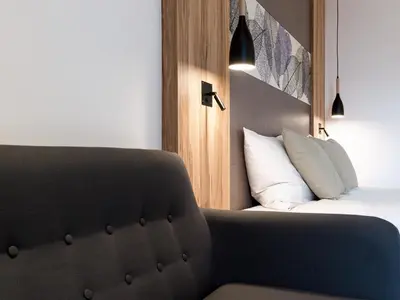 a hotel room with a bed and a chair at Hotel Ifinger in Schenna