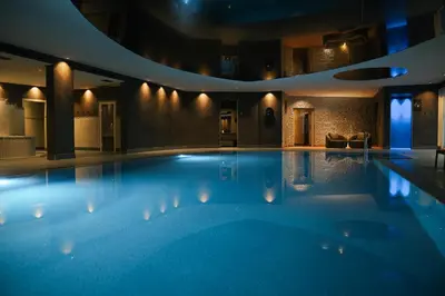 a swimming pool in a hotel at night at Hotel Ifinger in Schenna