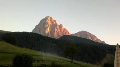 a mountain with the sun shining on it at Apartments Antines in Selva di Val Gardena