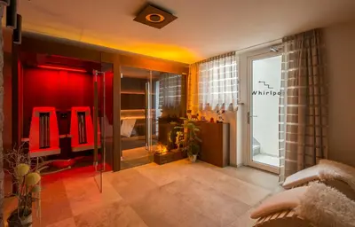 a room with red chairs and a room with a window at Apartments Antines in Selva di Val Gardena