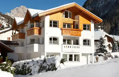 a building with snow in front of it at Apartments Antines in Selva di Val Gardena