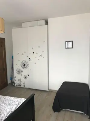 a bedroom with a bed and a wall with dandelions at Casa Corgol con vista lago e montagne in Predaia