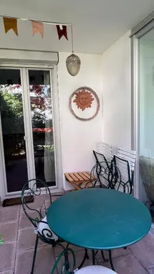 a green table and chairs on a patio with a table at Garden Suite in Bolzano