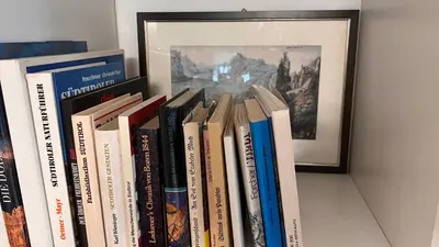 a row of books sitting on a shelf at Garden Suite in Bolzano