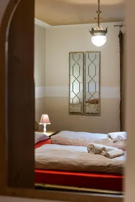 a bedroom with two beds and a mirror at Ciasa Gianot in Moena